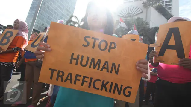 Participants of a peace rally carry posters reading ‘Stop Human Trafficking’ at the HI Roundabout area, Jakarta